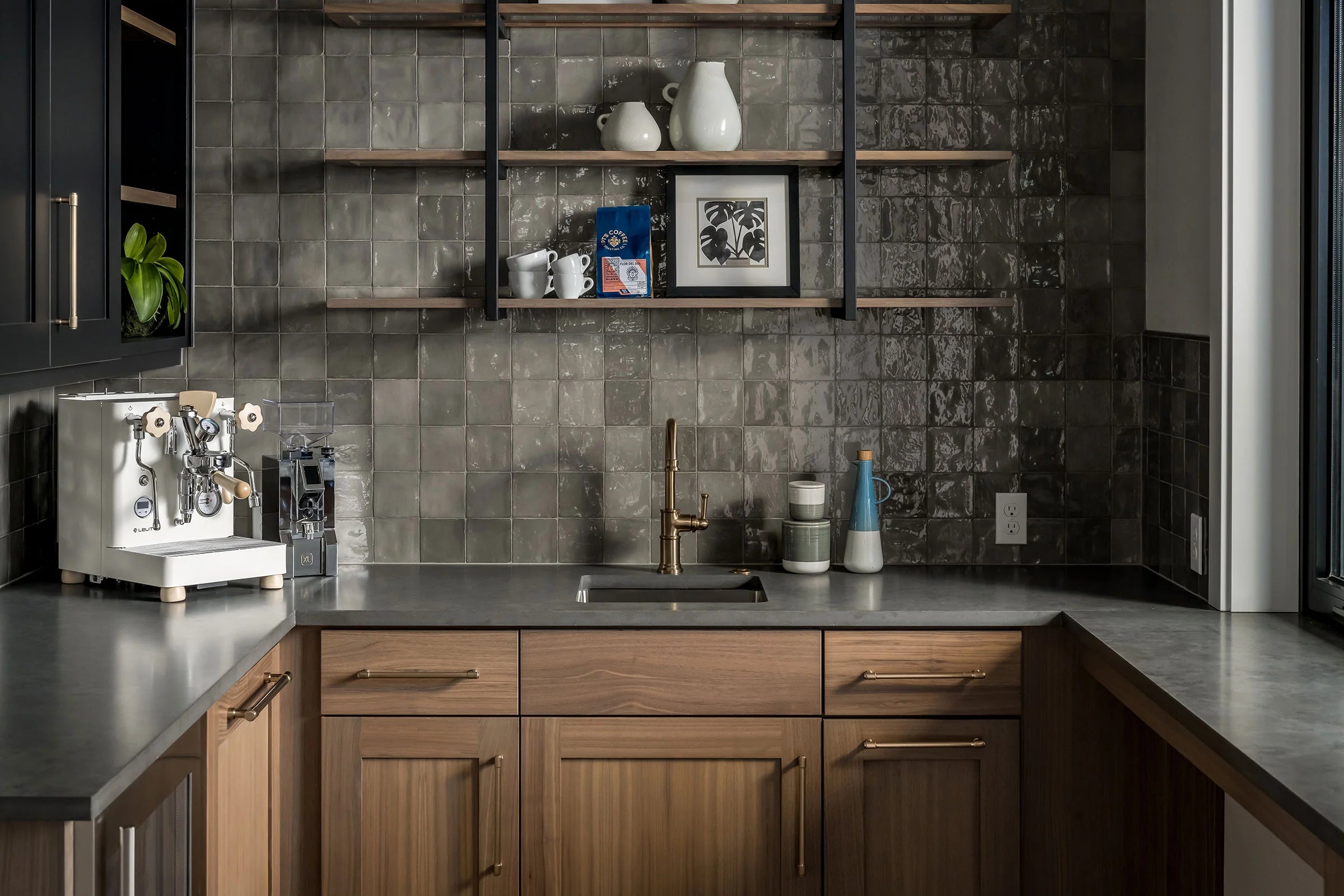 Modern kitchen with wooden cabinets, gray tiled backsplash, and a coffee machine.