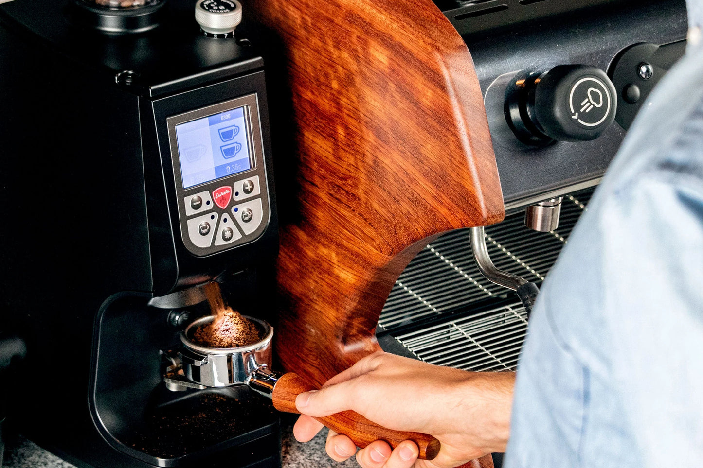 Eureka Atom Specialty 75 in action grinding coffee with hands-free portafilter fork