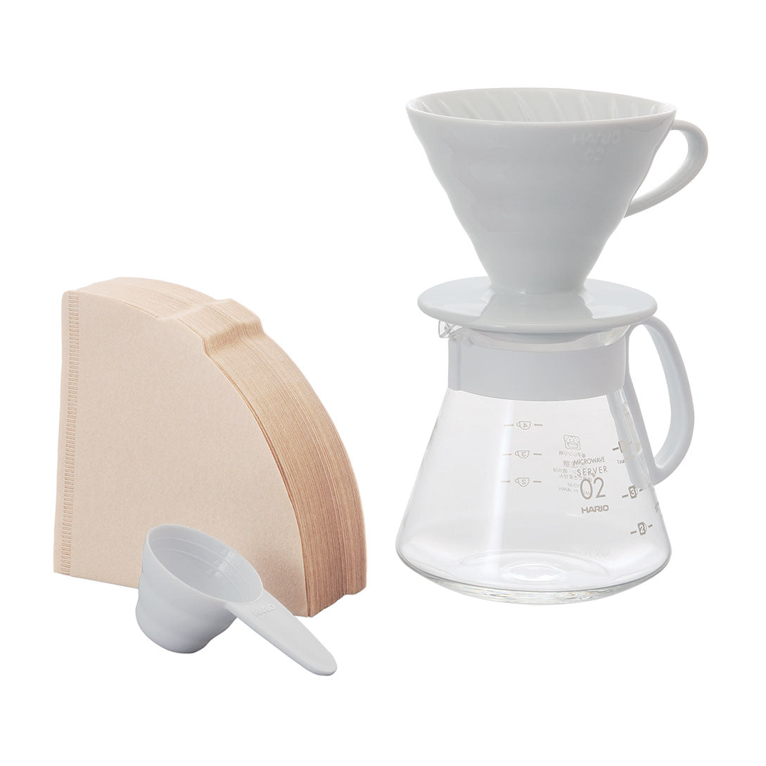 Hario V60 ceramic dripper in white with glass server and wooden scoop for pour-over coffee brewing