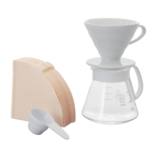 Hario V60 ceramic dripper in white with glass server and wooden scoop for pour-over coffee brewing