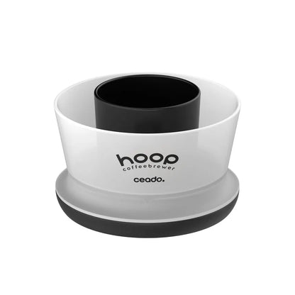 Ceado Hoop coffee brewing device featuring minimalist design with white cylindrical outer shell, black inner brewing chamber, gray circular base, and branded text reading 'hoop coffeebrewer ceado' on the front surface