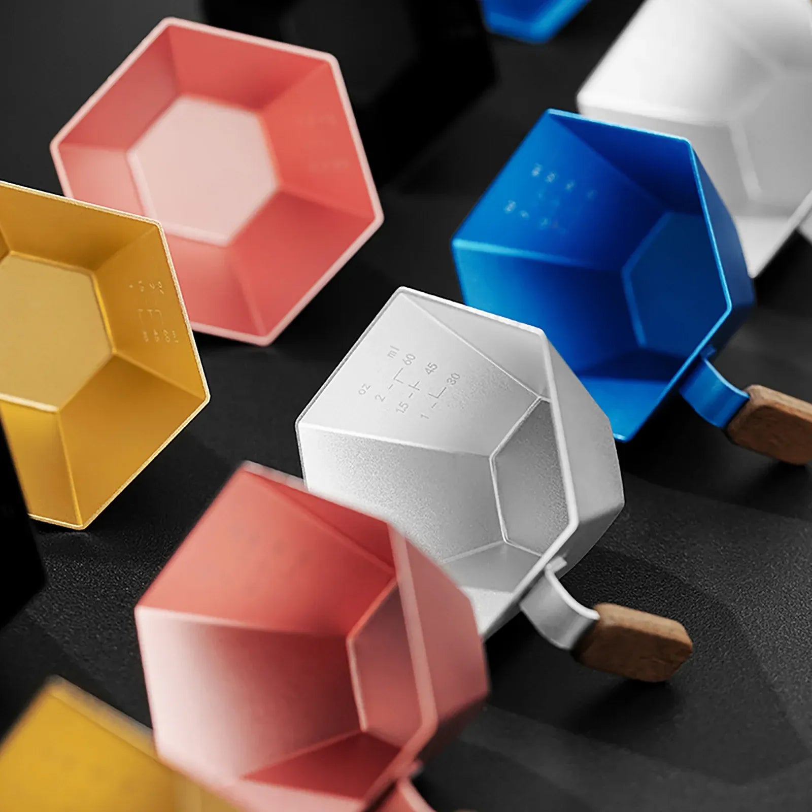 Colorful geometrically shaped scoops on a dark surface