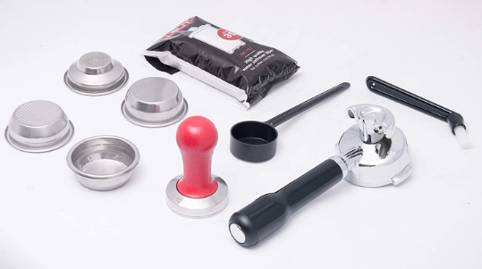 Collection of coffee brewing tools including a tamper, scoop, and various metal components on a white background.