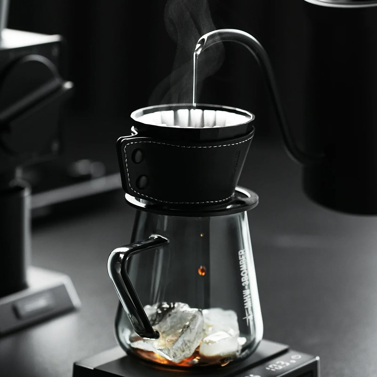Coffee brewing process with a glass carafe and black coffee filter.