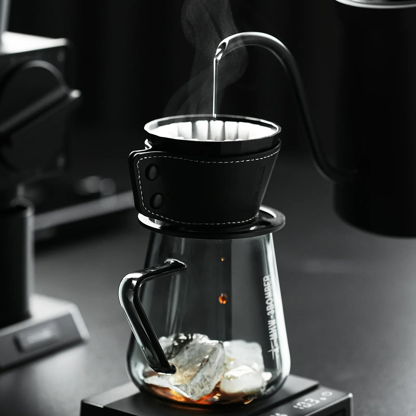 Coffee brewing process with a glass carafe and black coffee filter.