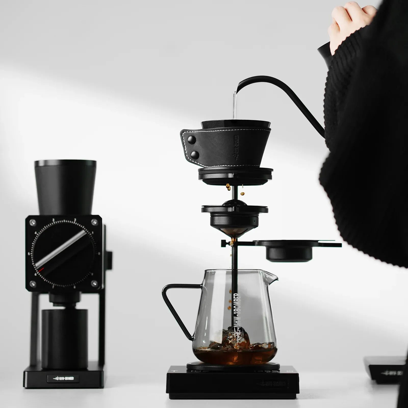 Coffee brewing setup with a grinder and pour-over coffee maker on a white background