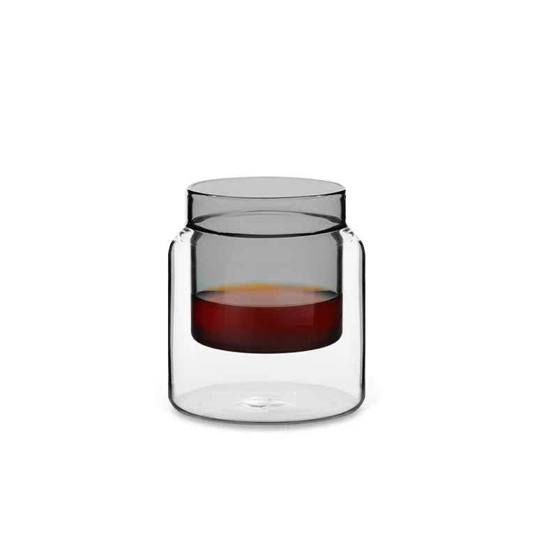 Clear glass candle holder with a red candle on a white background