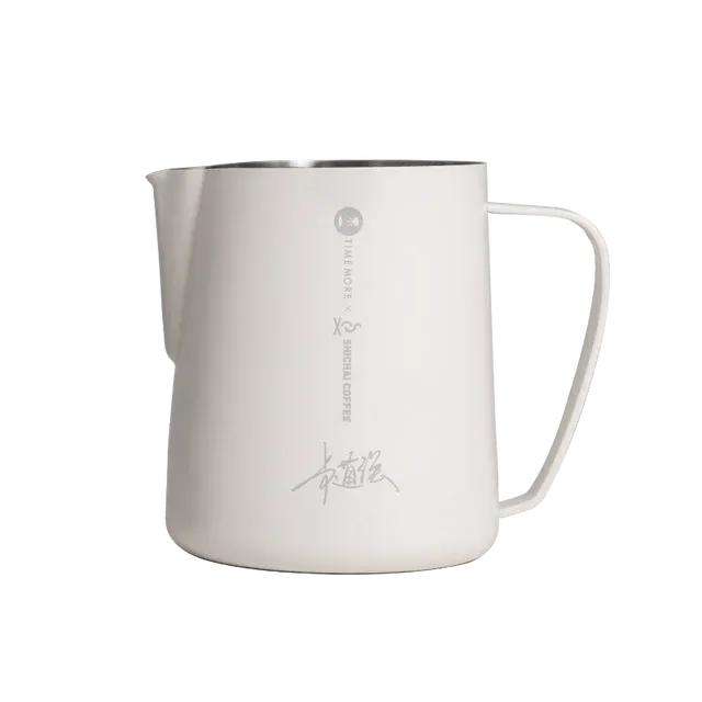 Stainless steel milk pitcher with handle on a white background