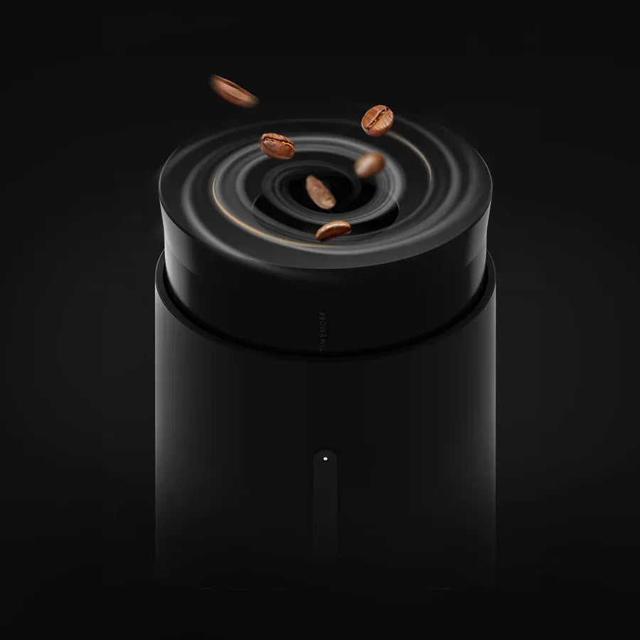 Black coffee grinder with coffee beans on a black background