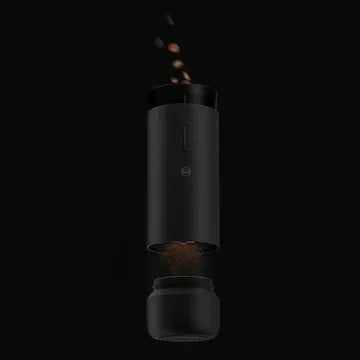 Black coffee grinder with coffee beans on a black background