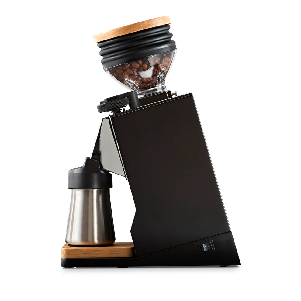 Rear angle of Eureka Mignon Single Dose PRO grinder, wooden lid and stainless steel cup visible.
