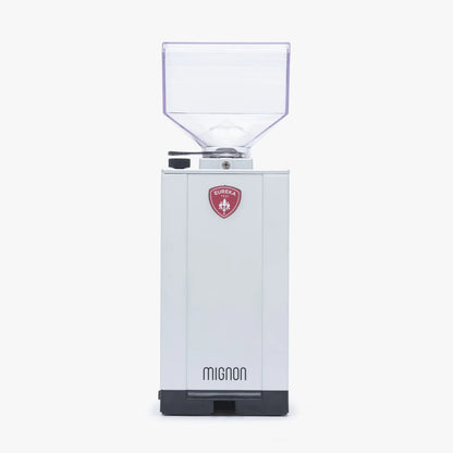 White Eureka Mignon Specialita grinder with coffee beans and brewing equipment.
