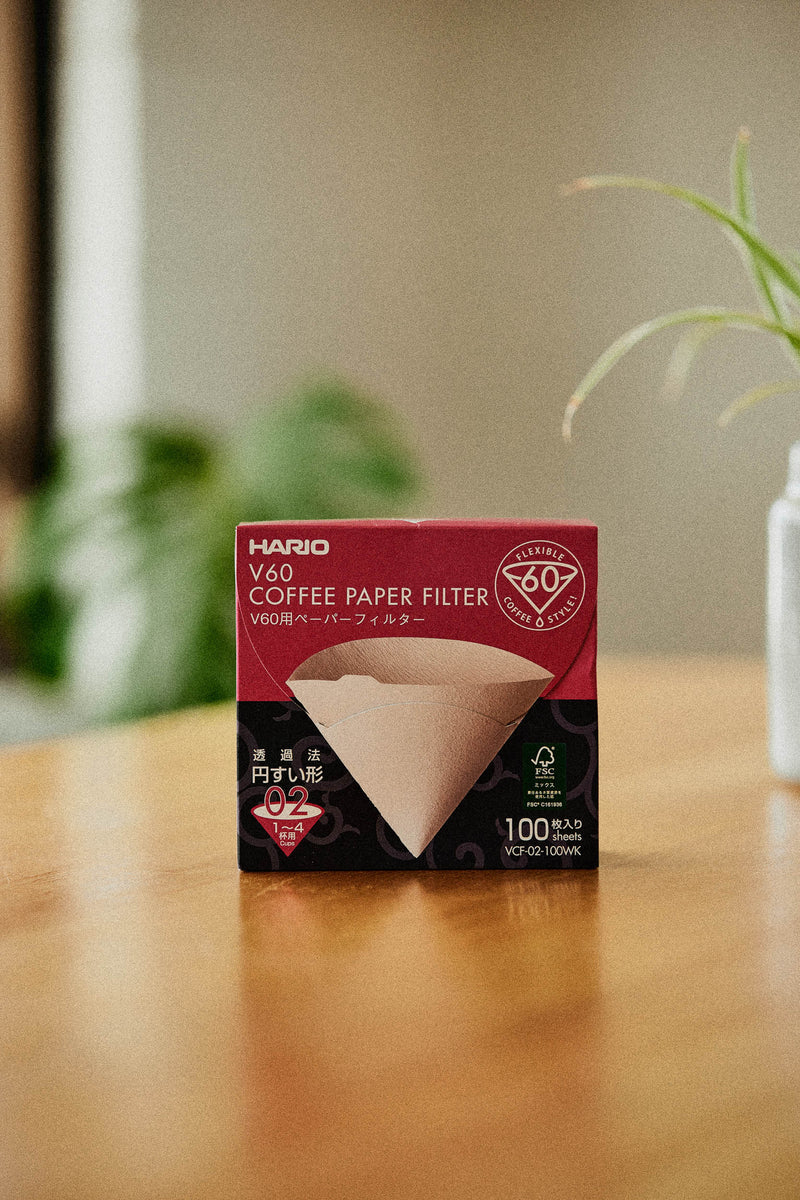 Hario V60 Paper Filters Size 03 White 40-Pack box packaging placed on wooden surface with natural background