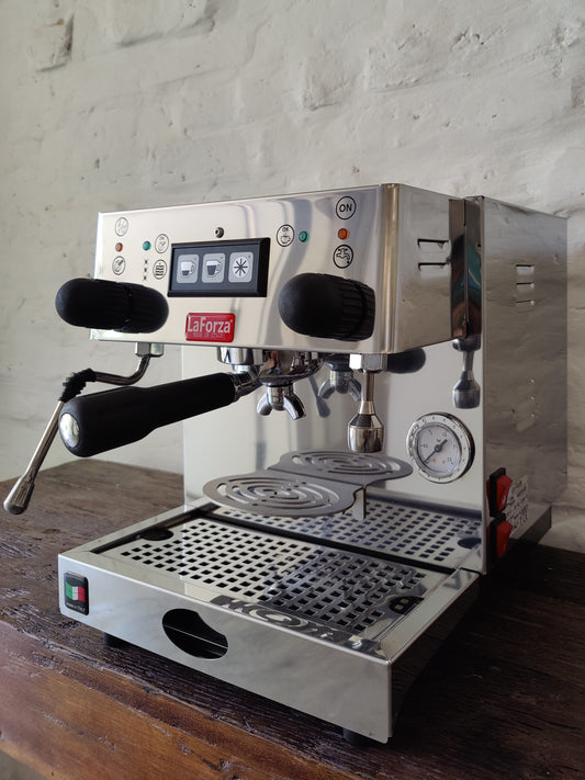 La Forza Olivia espresso machine front-left angle, dual group heads, stainless steel body.
