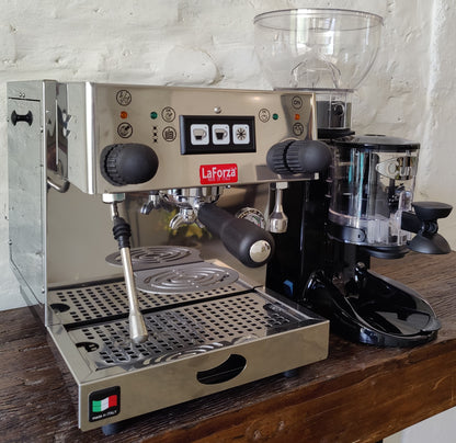 La Forza Olivia espresso machine with grinder setup on wooden counter, dual portafilters visible.
