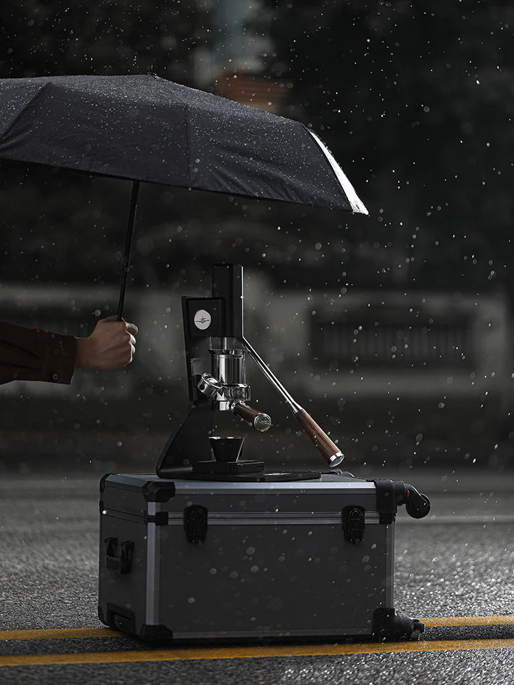Person holding an umbrella over a coffee machine on a rainy street