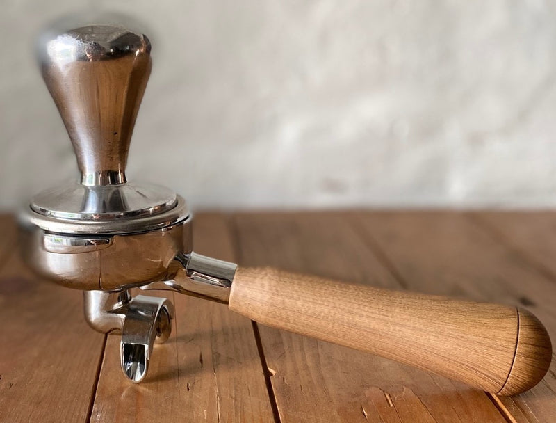 Coffee tamper collection showing aluminium and wooden handle options
